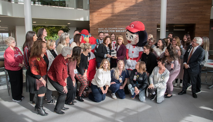 TriHealth employees surrounding heart mini trophy